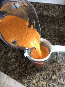 Straining orange sunshine juice