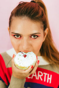 woman eating cupcake no guilt no self sabotage eat in moderation 